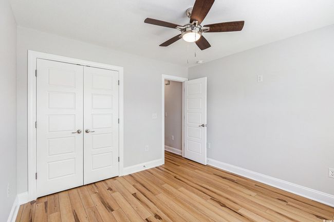 Unfurnished bedroom featuring light wood finished floors, a closet, and ceiling fan | Image 25