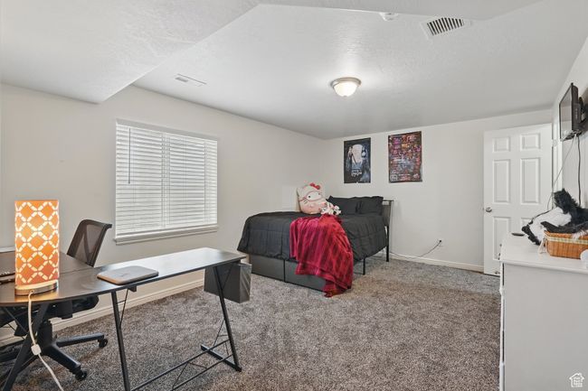 Bedroom featuring a textured ceiling, baseboards, visible vents, and carpet floors | Image 42