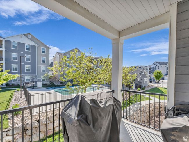 Balcony featuring view of pool area, area for grilling, and a residential view | Image 16