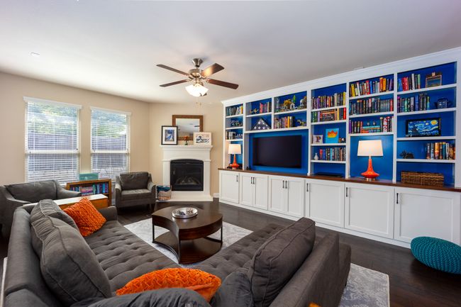 Living room with a ceiling fan, dark wood-style floors, and a glass covered fireplace | Image 8