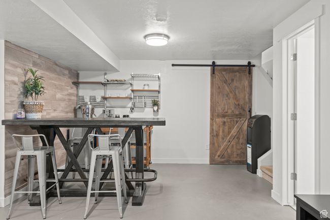 Bar featuring a barn door and finished concrete flooring | Image 40