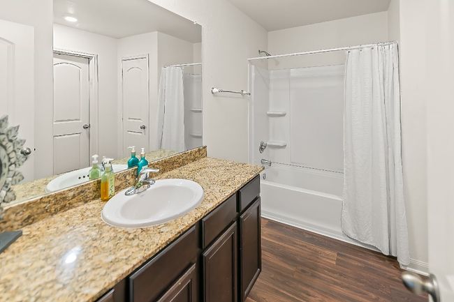 Bathroom featuring hardwood / wood-style floors, vanity, and shower / bath combo | Image 13