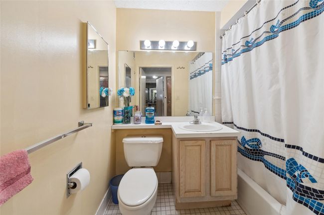Full bathroom featuring tile patterned floors, shower / bathtub combination with curtain, and vanity | Image 16