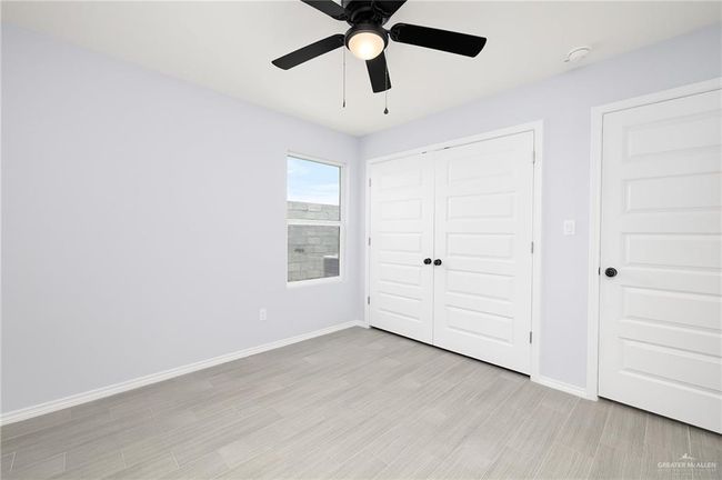 Unfurnished bedroom featuring baseboards, a closet, light wood-style flooring, and ceiling fan | Image 7