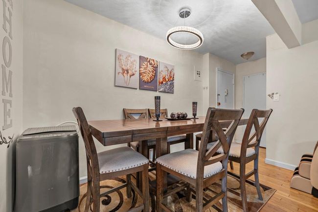 Dining room featuring a chandelier, light wood-type flooring, and baseboards | Image 5