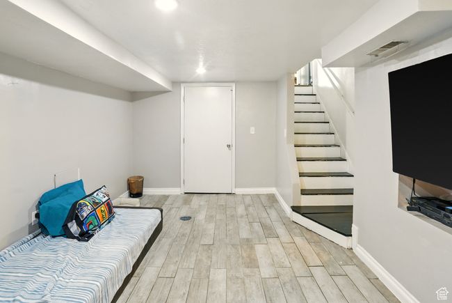 Finished below grade area featuring wood finished floors and stairway | Image 15