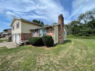 View of property exterior featuring a garage and a lawn | Image 3