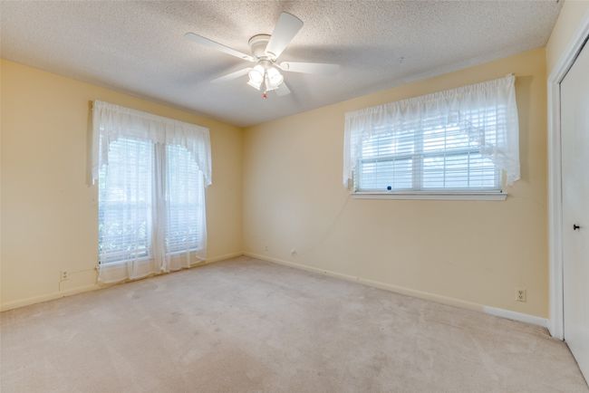 Spare room with plenty of natural light, carpet floors, a ceiling fan, a textured ceiling, and baseboards | Image 14