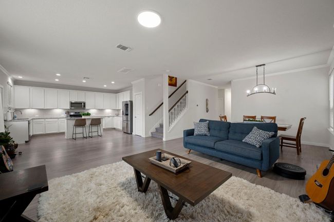 Living room featuring visible vents, crown molding, stairs, recessed lighting, and dark wood-type flooring | Image 8