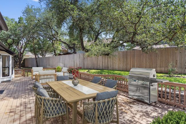 Fenced backyard featuring a wooden deck and outdoor dining space | Image 31