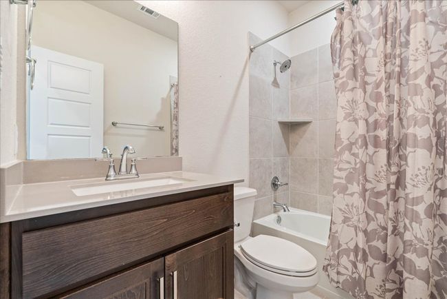 Full bath featuring toilet, vanity, shower / bath combination with curtain, and visible vents | Image 28