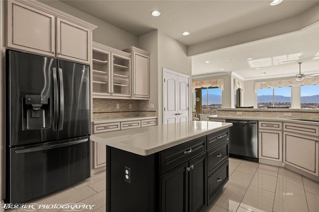 Kitchen with light tile patterned flooring, refrigerator with ice dispenser, light countertops, and stainless steel dishwasher | Image 14