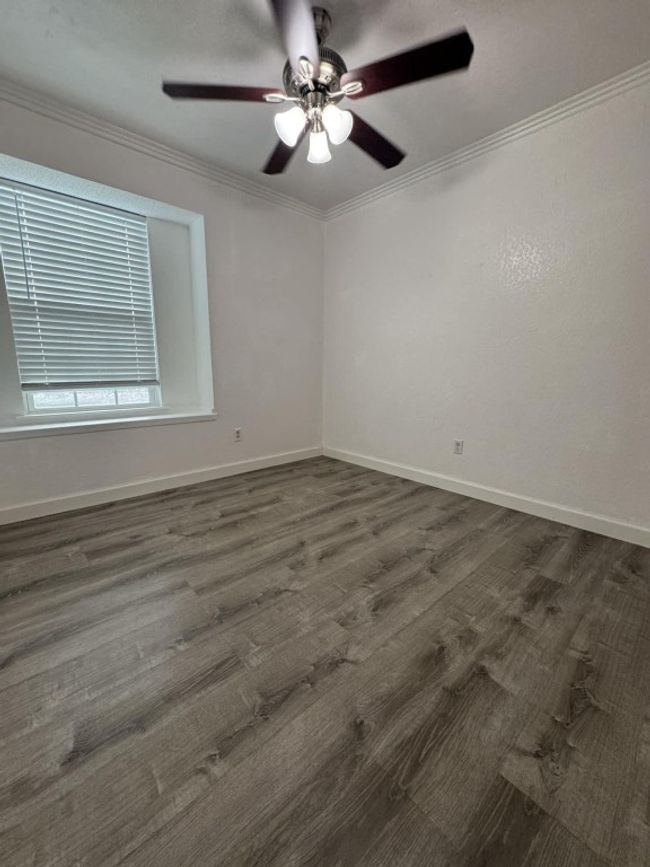 Unfurnished room featuring a ceiling fan, crown molding, and dark wood finished floors | Image 9