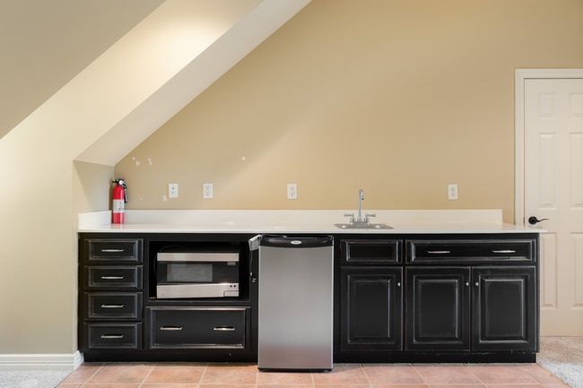Bar with indoor wet bar, a sink, appliances with stainless steel finishes, and light tile patterned flooring | Image 26