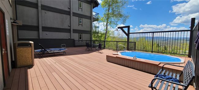 View of pool with a wooden deck and outdoor dining area | Image 29