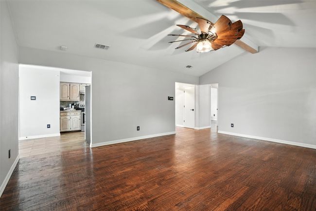 Spare room with ceiling fan, dark wood-style floors, and a smoke detector | Image 7