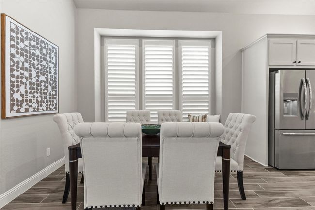 Dining area featuring natural light, wood finish tiled floors & plantation shutters | Image 10