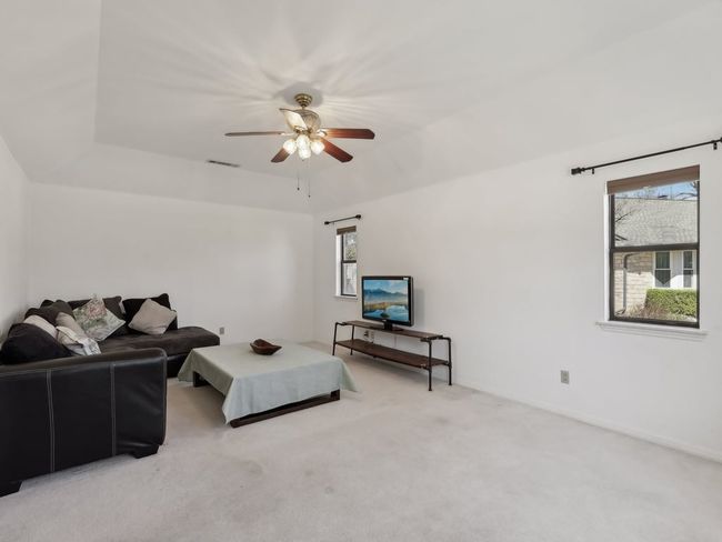 Living area with visible vents, ceiling fan, and light carpet | Image 6