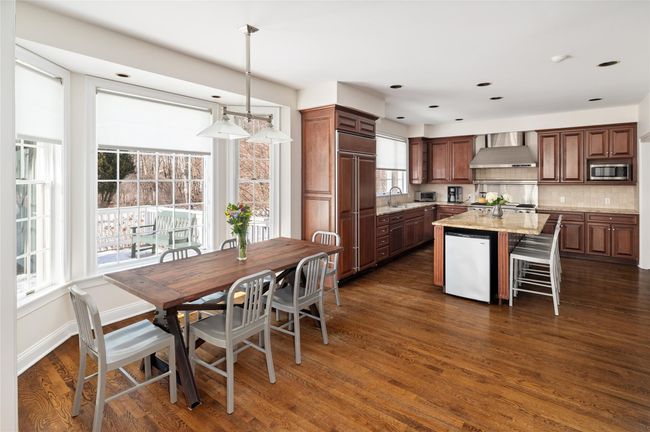 View of breakfast area and kitchen with a center island, natural stone countertops, and built in appliances | Image 14