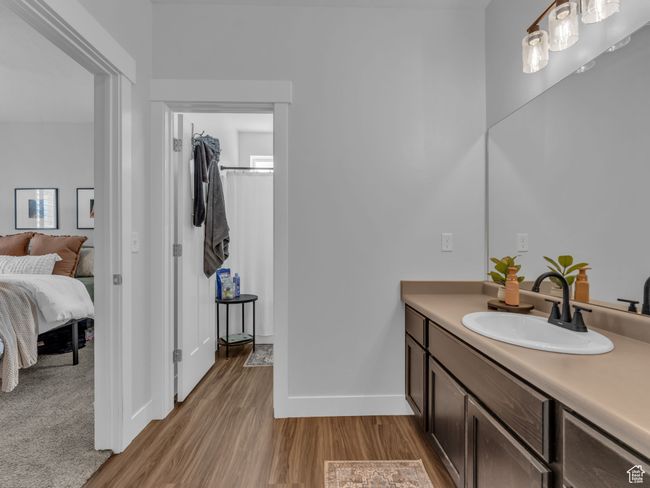 Ensuite bathroom featuring wood finished floors, vanity, and baseboards | Image 9