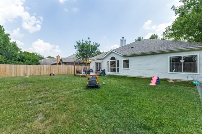 Back of house featuring a deck, roof with shingles, and a chimney | Image 21