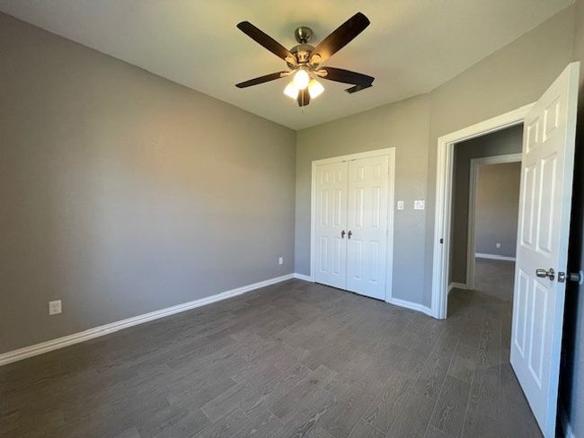 2nd bedroom featuring a ceiling fan, baseboards, wood-style finished floors, and a closet | Image 20