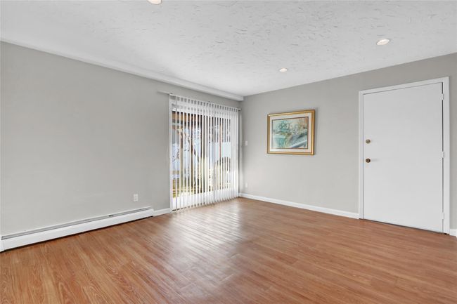 Unfurnished room featuring baseboard heating, light hardwood / wood-style flooring, and a textured ceiling | Image 28