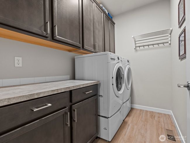 Adjacent, you'll find the strategically placed laundry room with plenty of additional storage. One of the many upgrades throughout the home. | Image 7
