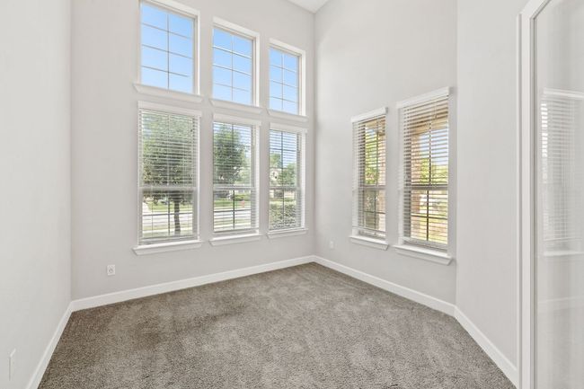 Unfurnished room featuring carpet, a high ceiling, and baseboards | Image 5