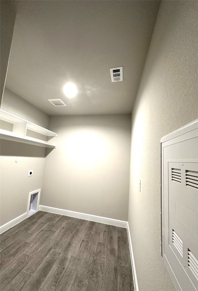 Washroom featuring hookup for an electric dryer, dark wood-style flooring, and a textured wall | Image 18