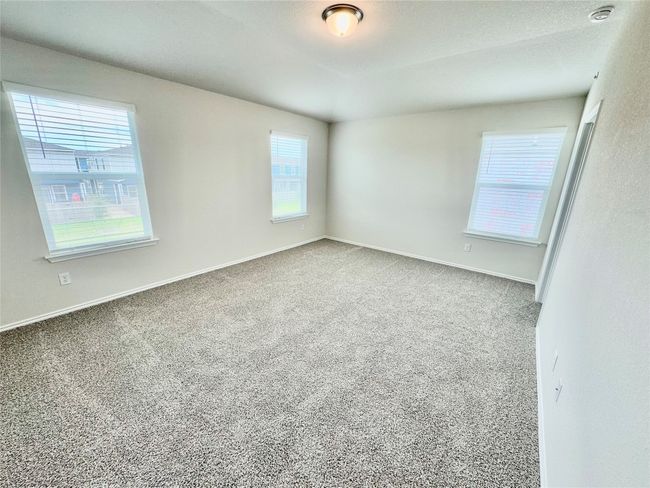 Empty room with healthy amount of natural light, carpet flooring, and a textured ceiling | Image 4