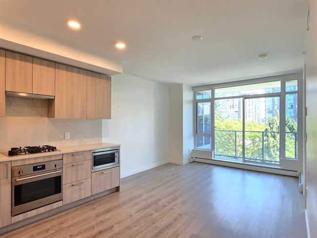 Kitchen with stainless steel appliances, baseboard heating, light brown cabinets, modern cabinets, and recessed lighting | Image 8