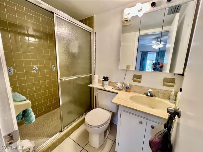 Full bathroom featuring a shower stall, toilet, vanity, and tile patterned floors | Image 14