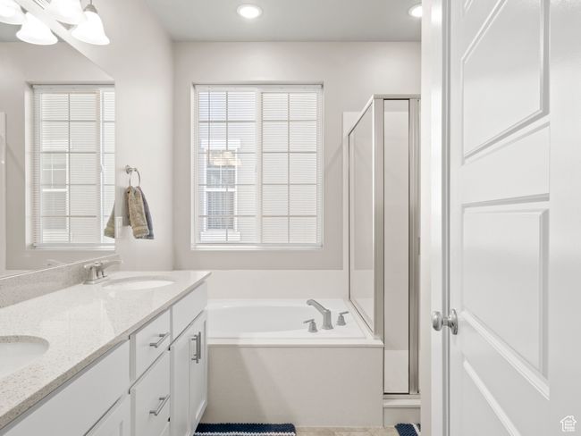 Bathroom with a stall shower, a bath, double vanity, and recessed lighting | Image 17