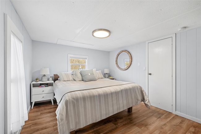 Bedroom with a textured ceiling and wood finished floors | Image 5