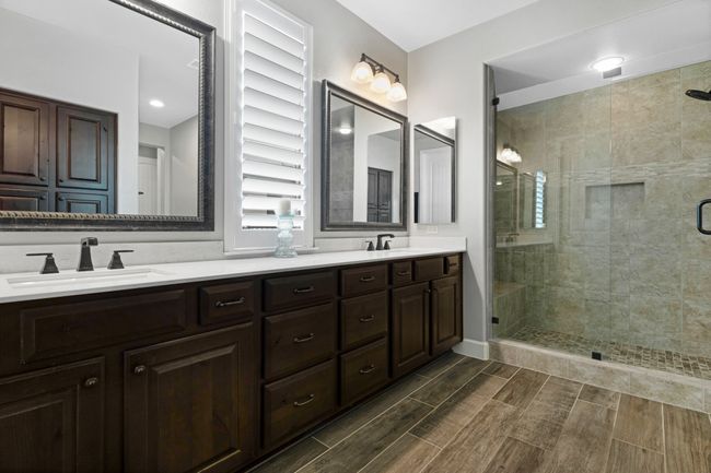 Full bath featuring double vanity, a shower stall, and wood tiled floors | Image 26