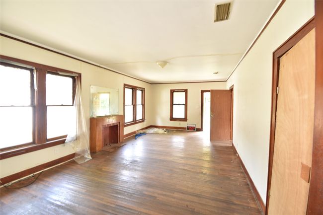Spare room featuring wood finished floors and crown molding | Image 15