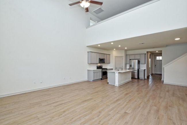 Unfurnished living room featuring light wood-type flooring, a sink, a ceiling fan, recessed lighting, and baseboards | Image 6