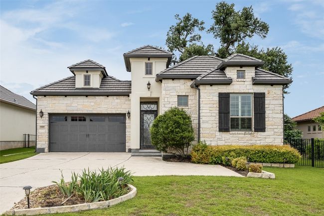View of front facade with stone siding, concrete driveway, and a garage | Image 39