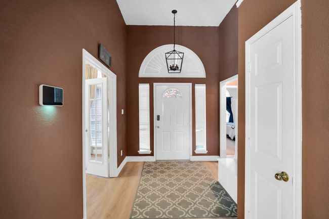 Foyer entrance with light wood-type flooring and a chandelier | Image 5