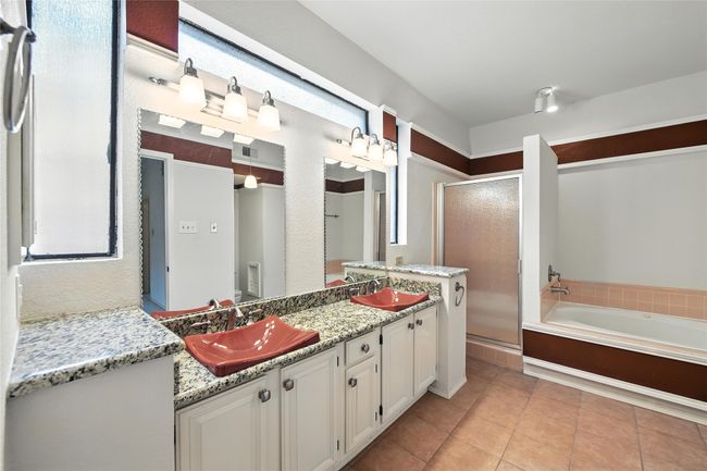 Bathroom featuring a shower stall, double vanity, a garden tub, and tile patterned flooring | Image 22