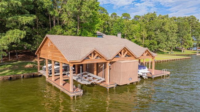 Dock featuring boat lift, a water view, and view of scattered trees | Image 7