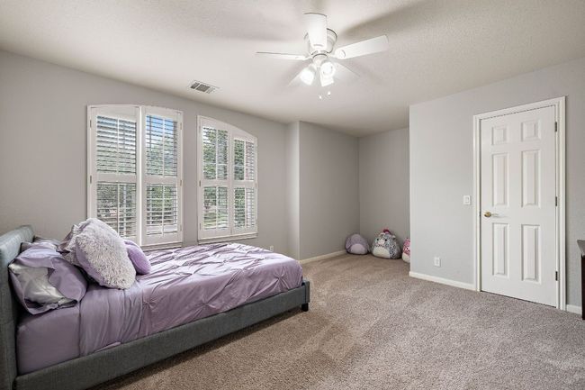 Upstairs Guest Bedroom with an extra desk nook, lots of natural light, plantation shutters, and a walk-in closet. | Image 24