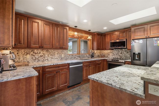 Gorgeous granite countertops and backsplash. Remodeled kitchen in 2022 with heated slate flooring. Lots of natural lights with skylights. | Image 8