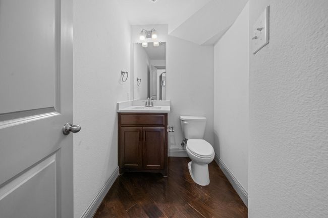Half bath featuring baseboards, wood finished floors, vanity, and toilet | Image 10