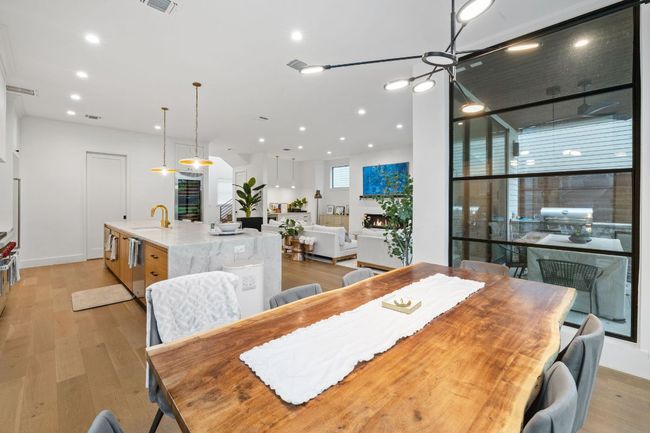 Dining space featuring light wood-style floors, recessed lighting, and a chandelier | Image 18