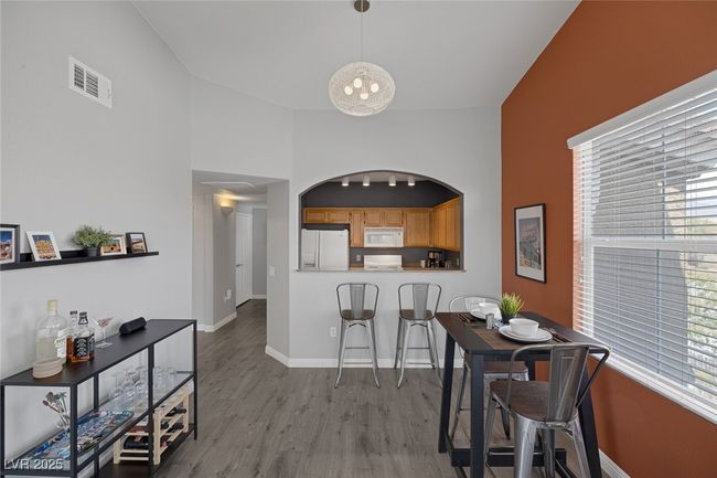 Dining area with baseboards, a notable chandelier, visible vents, and wood finished floors | Image 13