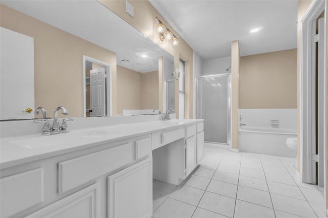 Primary en-suite bathroom features double sinks, a large soaking tub and separate shower. | Image 18