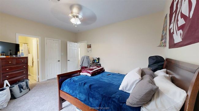 Carpeted bedroom featuring a ceiling fan and connected bathroom | Image 17