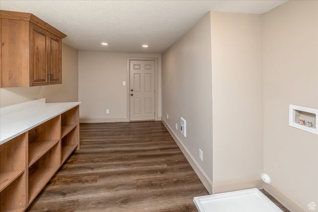 Laundry room featuring recessed lighting, hookup for a washing machine, dark wood finished floors, a textured ceiling, and cabinet space | Image 41
